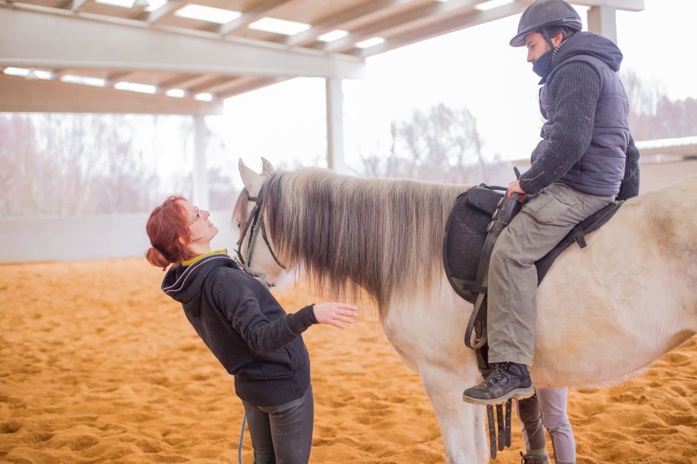 An instructor coaching a rider in the arena